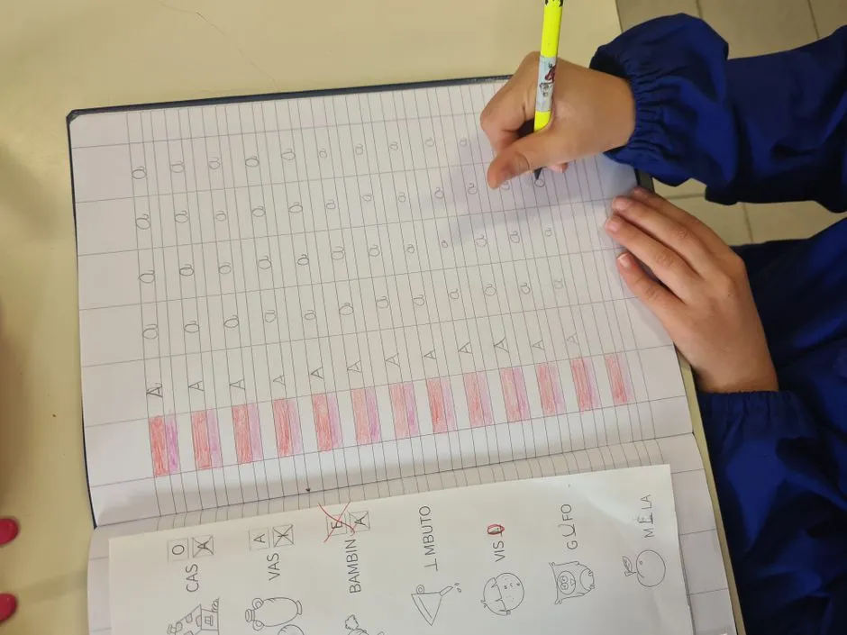 A child writing on a worksheet with a pencil