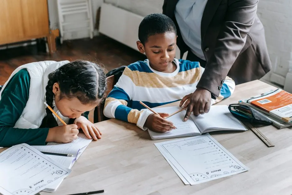 A teacher helping a small group of students with a classroom worksheet